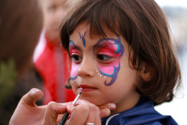 Young girl having her face painted at Norfolk festival
